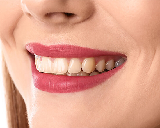 Close-up of healthy white teeth against dark clinical background